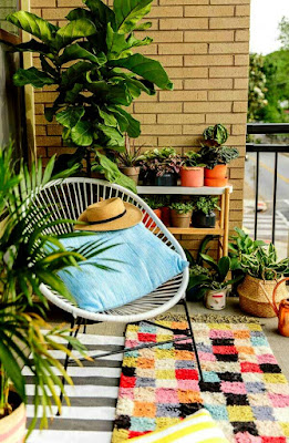 Relaxing balcony design ideas with white chair and pillow on colorful rugs