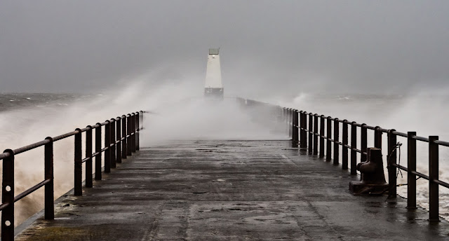 Photo of spray being blown across Maryport Pier by the strong wind