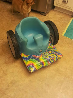 baby Bumbo seat with wheels and tie-dyed foot platform