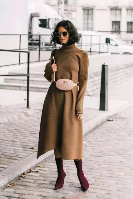 A woman wears a camel pure color one-piece knit, dressed with maroon sock boots.