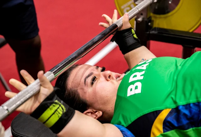 Mariana D'Andrea, atleta do halterofilismo paralímpico, se prepara para mais uma tentativa de erguer o peso. Ela está segurando a barra, antes do levantamento.