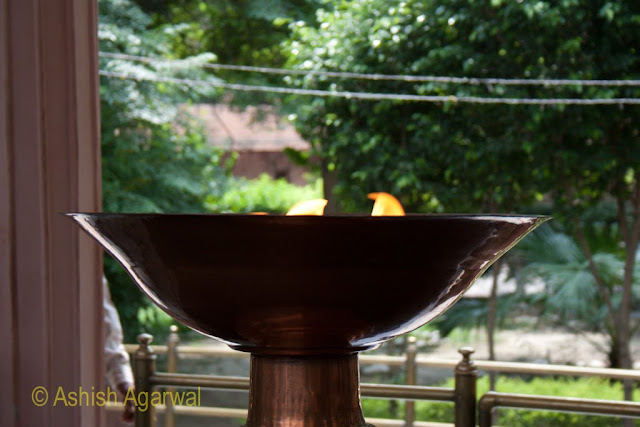 Urn with the memorial flame at the Jallianwala Bagh in Amritsar, garden in the background