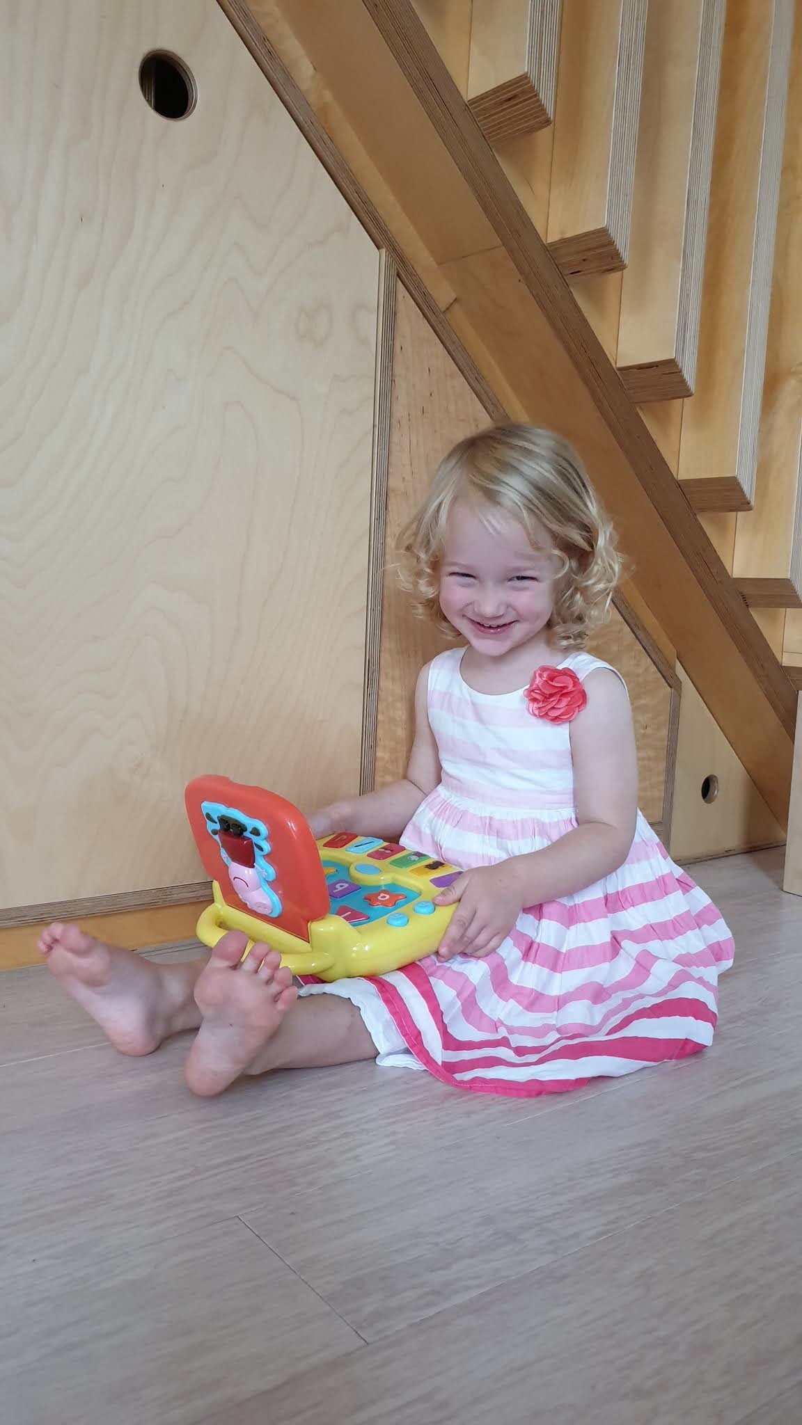 toddler smiling with a peppa pig laptop