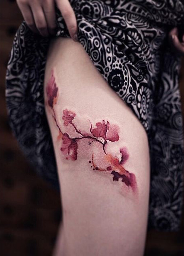 Maravilhoso olhando a flor de cerejeira tatuagem na coxa. A luz e o efeito de aquarela da tatuagem fornece o design realmente um místico e fascinante olhar. (Foto: Fontes de imagem)