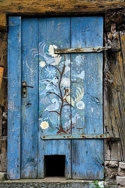 White birds painted on a small blue door in Bavaria, Germany