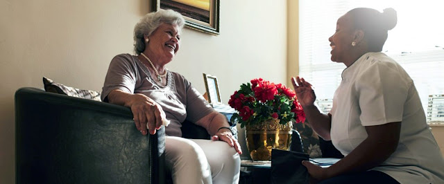 Home care provider chatting with senior woman with dementia