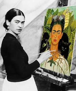 Frida Kahlo with her painting