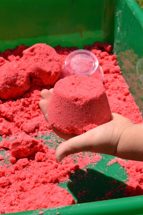 Watermelon Moon Sand Recipe- If you are unfamiliar with moon sand it is truly amazing stuff.  It is mold-able but crumbly and produces the best sandcastles.  It is really easy to make at home, too.