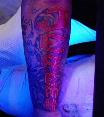 UV ink tattoo shown under black light. Blacklight Tattoo Ink