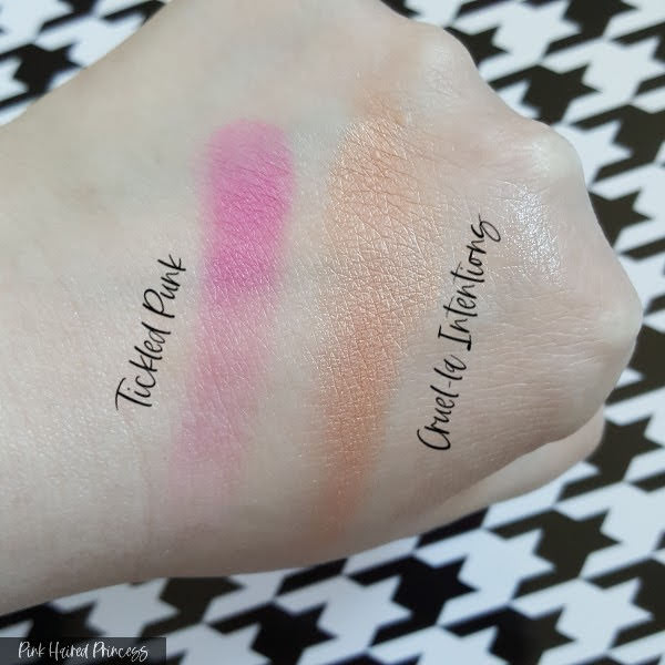pink and gold powder blush swatches on pale skinned hand