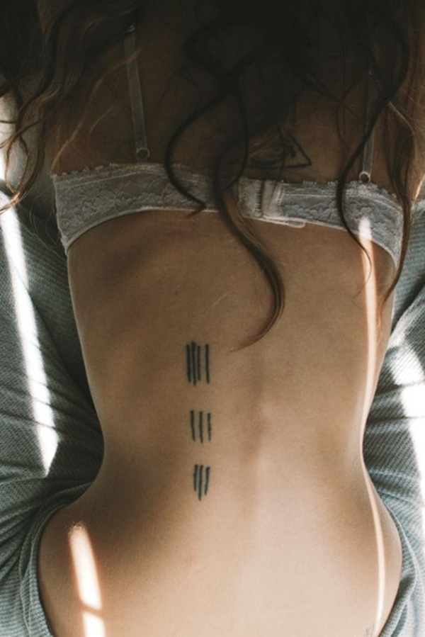 Instável tally marcas são aglutinados em grupos de quatro, três e três, nesta preto de volta da tatuagem.