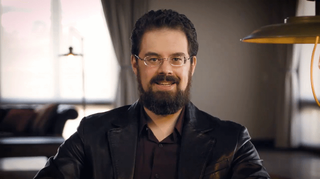 2/2 Handsome Bearded Author Wearing glasses, deep red dress shirt and soft black leather blazer