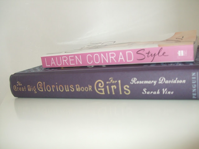 small pink book spine on large purple book spine