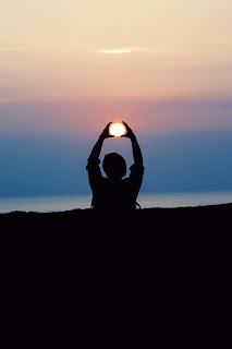 person "holding" the sun during sunset