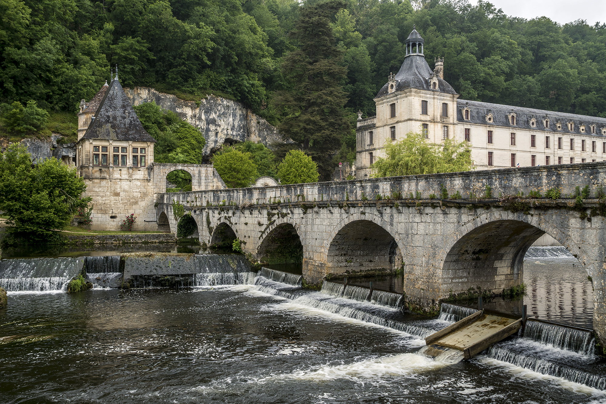 Vista de Brantome, en el Perigord, Francia, del puente de piedra y la abadía benedictina de Saint-Pierre