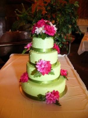 Four tier green round wedding cake with bright pink flowers