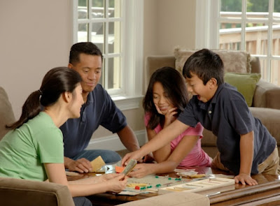 A family of four playing board games in the living room