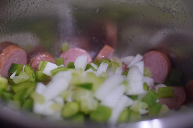 The diced green pepper, onions, and celery added to the instant pot with the sausage. 