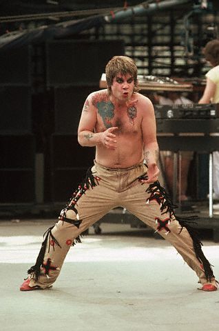 A rocker musician having dragon head tattoo on his shoulder.