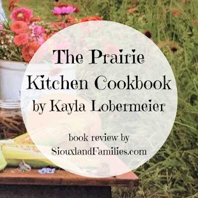 in background, corn and wildlflowers from the cover of the book, in the foreground, the words "The Prairie Kitchen Cookbook by Kayla Lobermeier, review by SiouxlandFamilies.com"