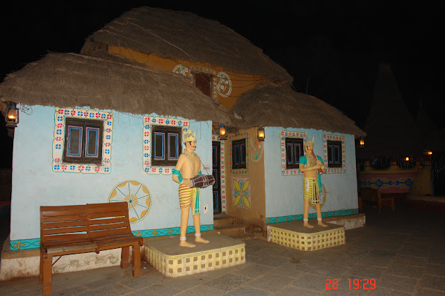 Photo of Hut with statues of 2 musicians outside in the village of Chokhi Dhani