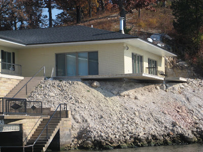 a home built on the edge of the shoreline. The ground underneath the foundation is severely eroded