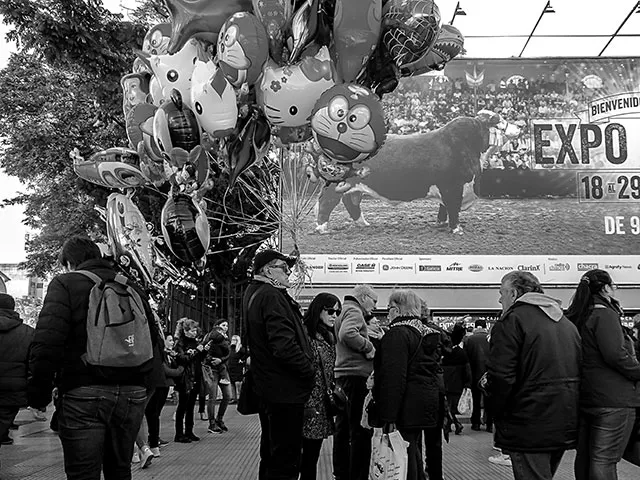 ByN.Persona vendiendo globos frente a la Exposición Rural.