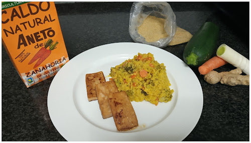 Emplatado del cuscús con el tofu. Detrás un brick de caldo aneto de zanahoria y bolsa con cuscús