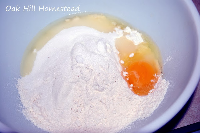 Flour, sugar and an egg in a mixing bowl