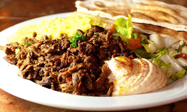 Beef Shawarma, Salad , Pita Bread and Tahaini Dressing in a serving dish