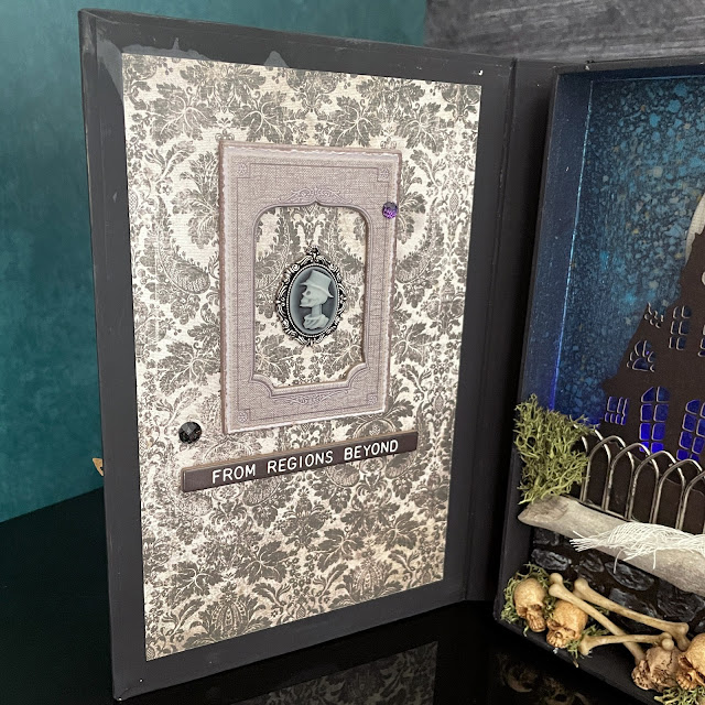 Lit Halloween book box decorated with Tim Holtz Halloween Idea-ology; Tim Holtz Distress Inks and Sprays; and Tim Holtz Sizzix Haunted House Thinlit and Cracked A5 Texture Fade embossing folder.