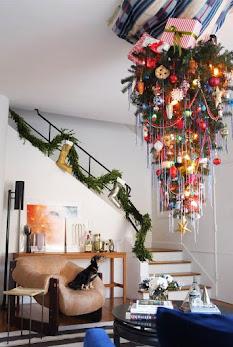 An upside-down Christmas tree hanging in the stairwell of a home