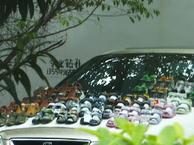 Street Hawker selling shoes on car bonnet in Shenzhen