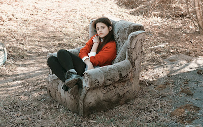 foto de niña sentada en medio de bosque  
