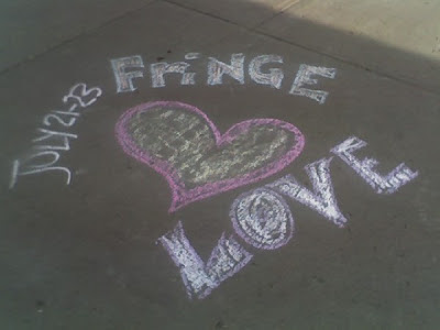A chalk sidewalk drawing promoting Athabasca's Fringe Festival.  A pink heart with the words Fringe Love