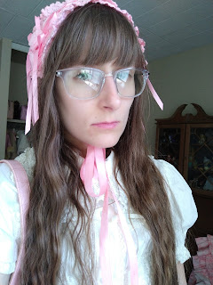 Lolita girl with big glasses, a white blouse and a pink old school headdress.