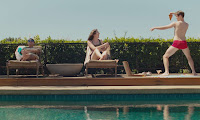 three people by a swimming pool