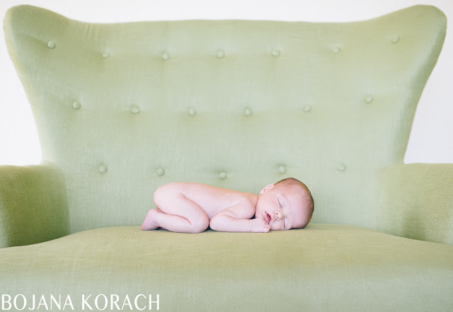 newborn baby boy photographed sleeping on a green chair