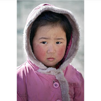 Little girl, dressed in pink sad as she is facing ill effects of war