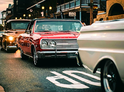 Vintage and customized cars motoring down main street.