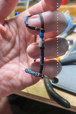 Miniature bosal with hangar and earloop held up with a hand