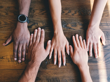 Many friends are seated, with their hands resting on the table after using an online chat room.