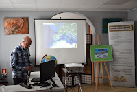 Grzegorz Trybuchowski prowadzi prelekcję nt. podrózy na Wyspy Kanaryjskie. W tle wyświetlane z rzutnika na ekranie zdjęcia z wyprawy.