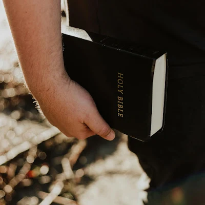 a close up of a person holding a bible, bible verses about leadership