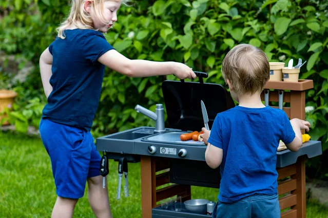 A 6 year old playing with the bbq and a 3 year old with a kitchen knife