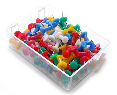 brightly coloured push pins, or map pins in a clear plastic container, copyright J. Gracey Stinson