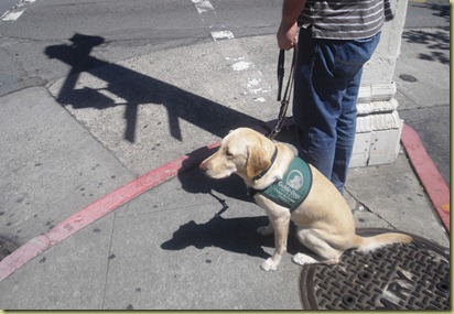 Reyna comfortably sits on a man hole cover while she waits to cross the street.