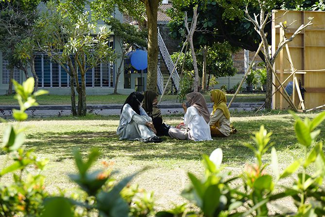 Sekumpulan mahasiswa asyik berdiskusi santai di taman UNISA Yogyakarta