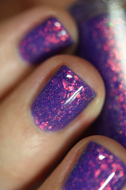 purple nail polish packed with shifty flakes that appear green and orange and gold