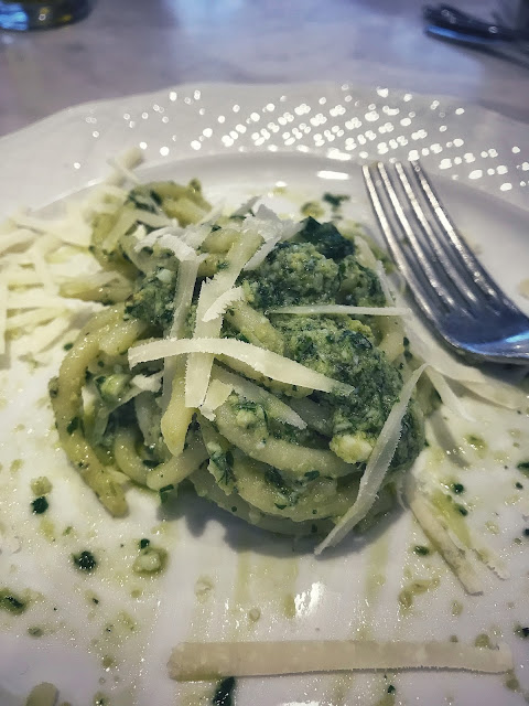 Italian Pici Spaghetti topped with pesto sauce and parmesan cheese